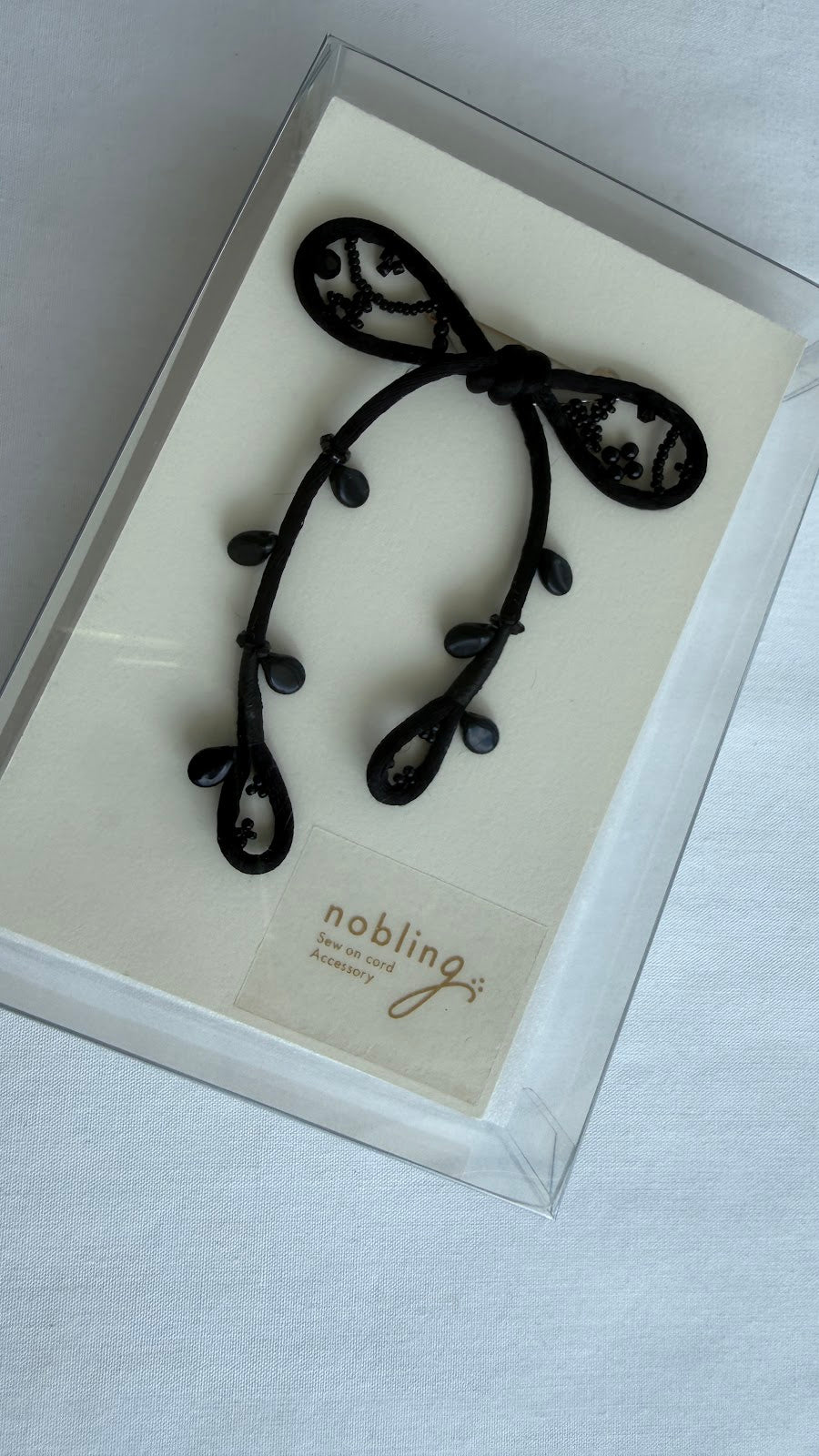 Black ribbon brooch in nobling branded packaging